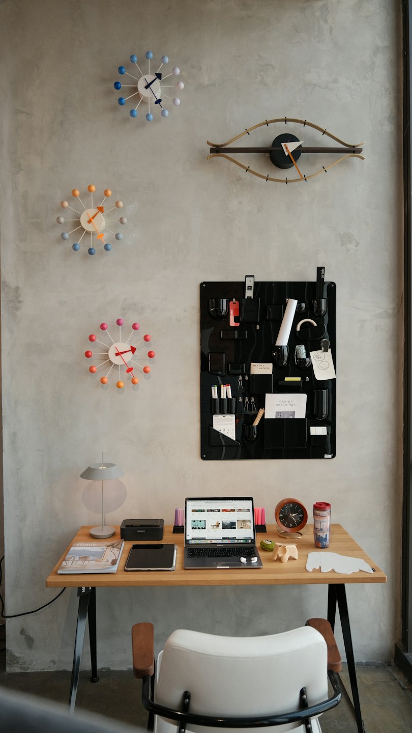 Ufficio moderno con laptop e orologi a muro.